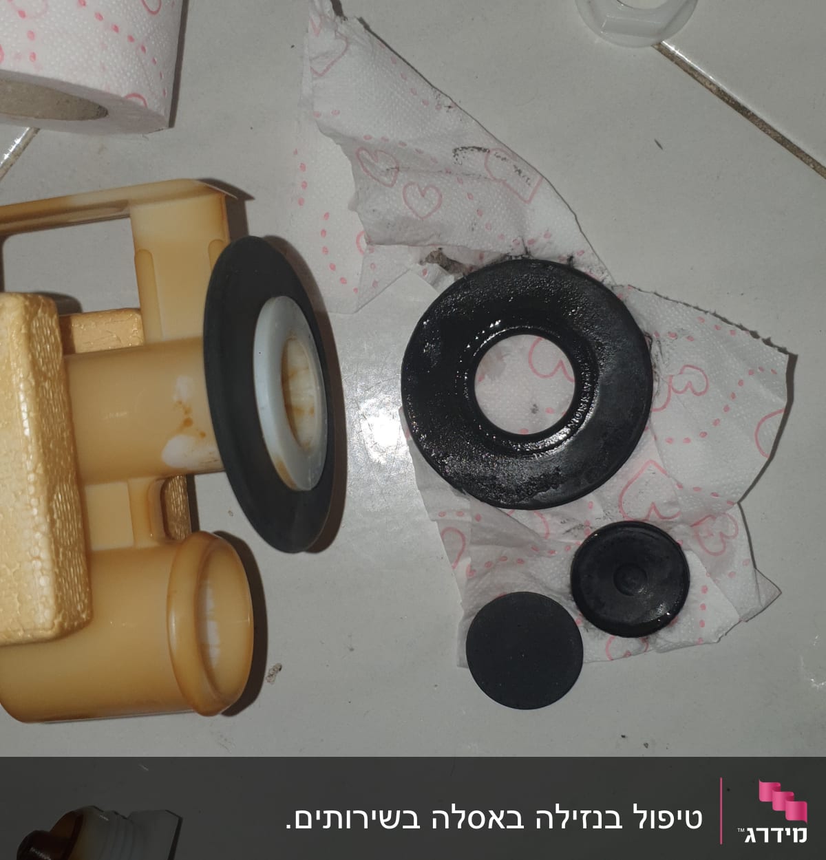 חלקי אינסטלציה וכלי עבודה על רצפה לבנה